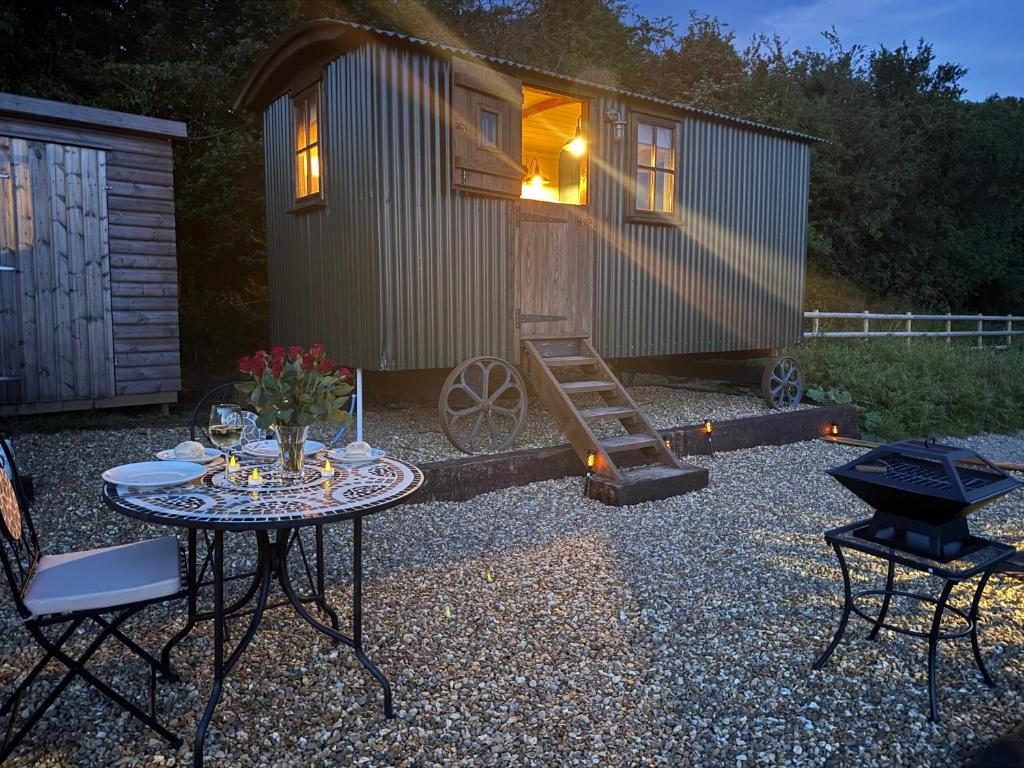 Table set for dinner beside the hut, with the barbecue ready